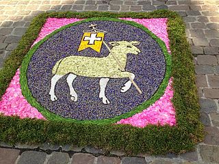 Blumenteppich mit Lamm Gottes als Motiv