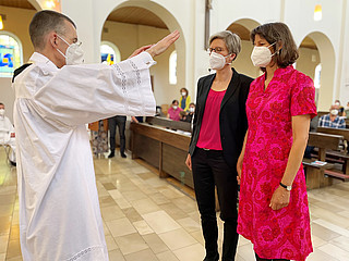 Ein Paar bestehend aus zwei Frauen lässt sich 2021 in der Münchner Kirche St. Benedikt von einem Priester segnen.