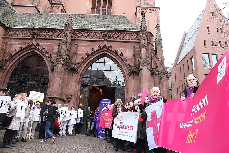 Frauen demonstrieren vor dem Frankfurter Dom mit Plakaten für mehr Rechte in der katholischen Kirche