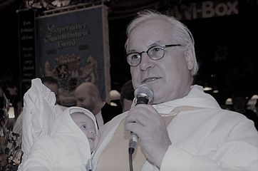 Pater Paul mit einem Täufling am Arm