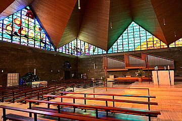 Innenraum der Kirche Sankt Hildegard in Pasing mit den bunten Glasfenstern
