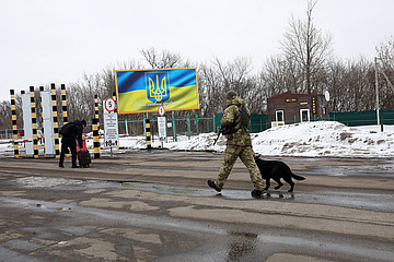 Soldaten mit Wachhund bewachen einen Grenzpunkt.