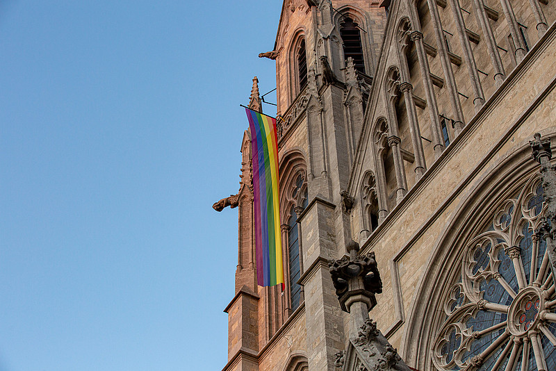 Über dem Haupteingang der Kirche St.Paul weht vor blauen Himmel die Regenbogenfahne.
