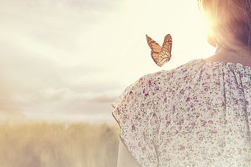 Schmetterling an der Schulter einer Frau