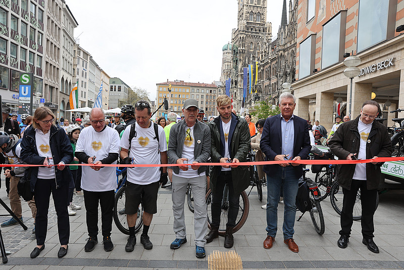 Amtschefin, Teilnehmende, Oberbürgermeister Reiter und Generalvikar Klingan durchschneiden rotes Band auf dem Münchner Marienplatz