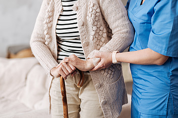 Pflegerin hält Hand einer alten Dame