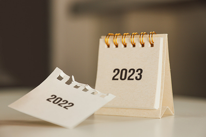 Kalender zeigt Jahreszahl 2023, herabfallendes Kalenderblatt "2022"