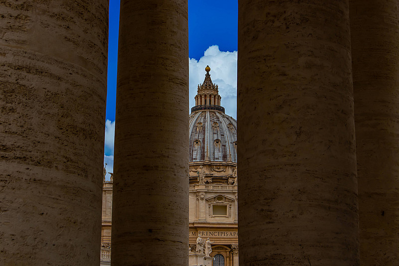 Blick durch die Kolonaden auf den Petersdom in Rom